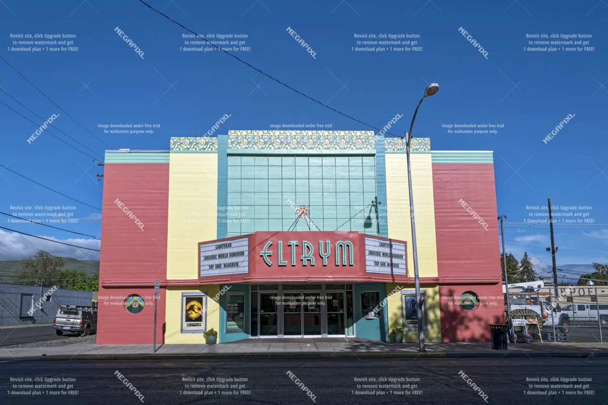 The ELTRYM marquee dominates this image, with its colorful facade and ornate detailing. The scene evokes a sense of nostalgia and community, suggesting the presence of unique attractions and cultural events downtown.